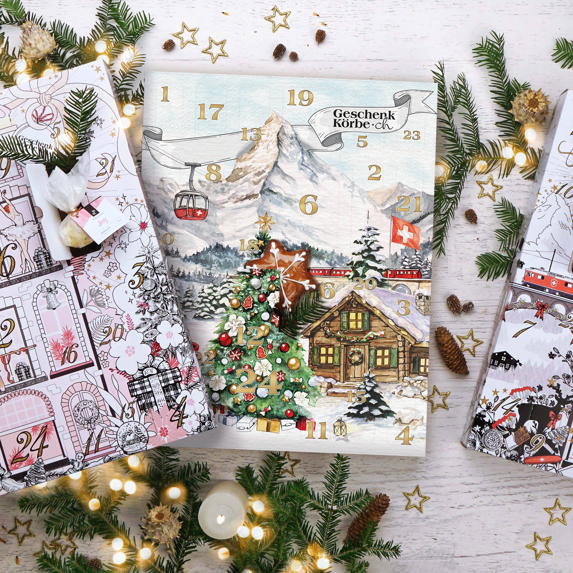 Drei Adventskalender mit Schweizer Bergmotiven, Tannenzweigen und Lichterketten auf weißem Holzuntergrund.