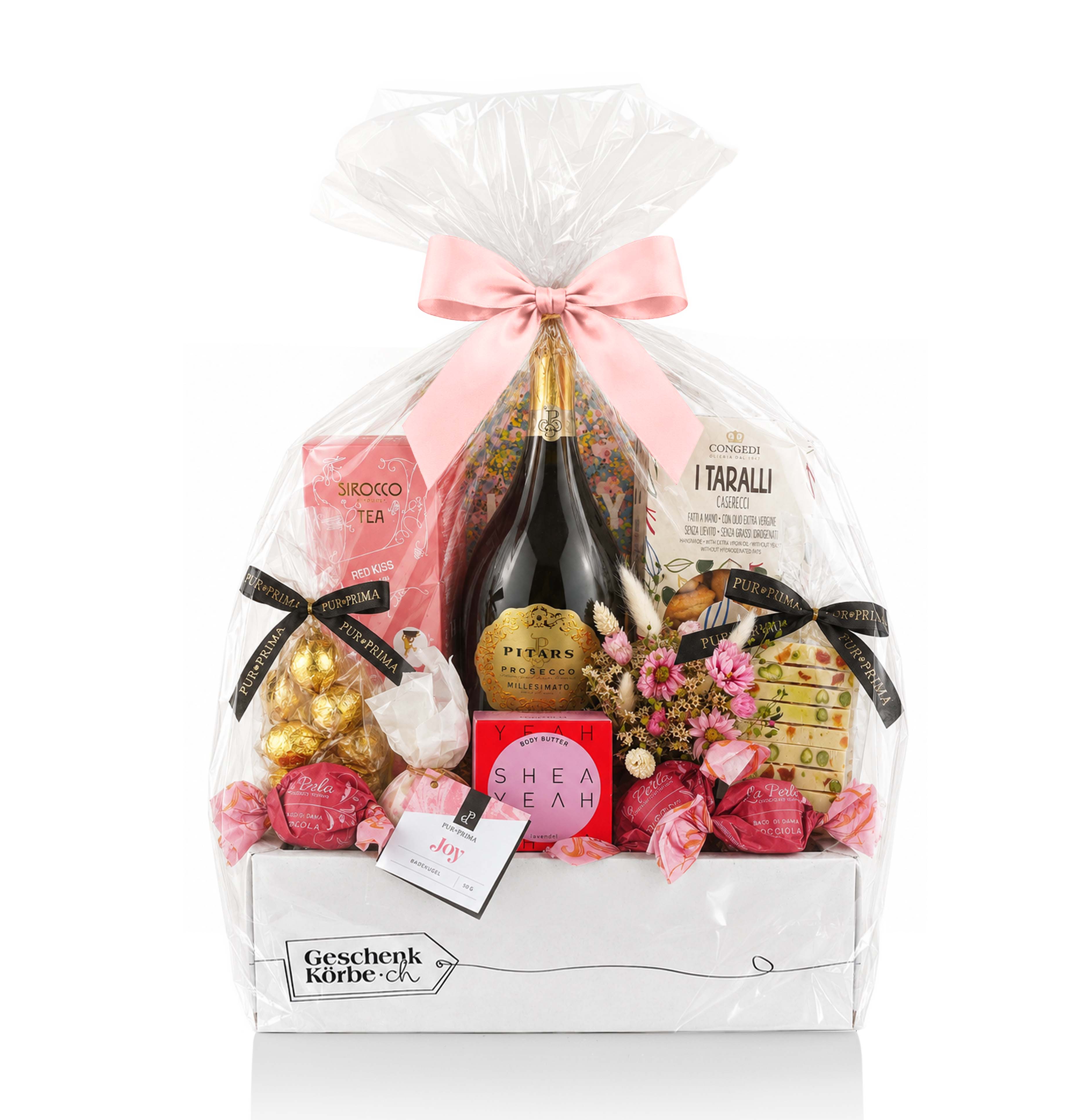 Geschenkkorb mit Pitars Prosecco, Sirocco-Tee, Congedi Taralli, Shea Yeah-Körperbutter, Pralinen und Blumen in einer Schachtel.
