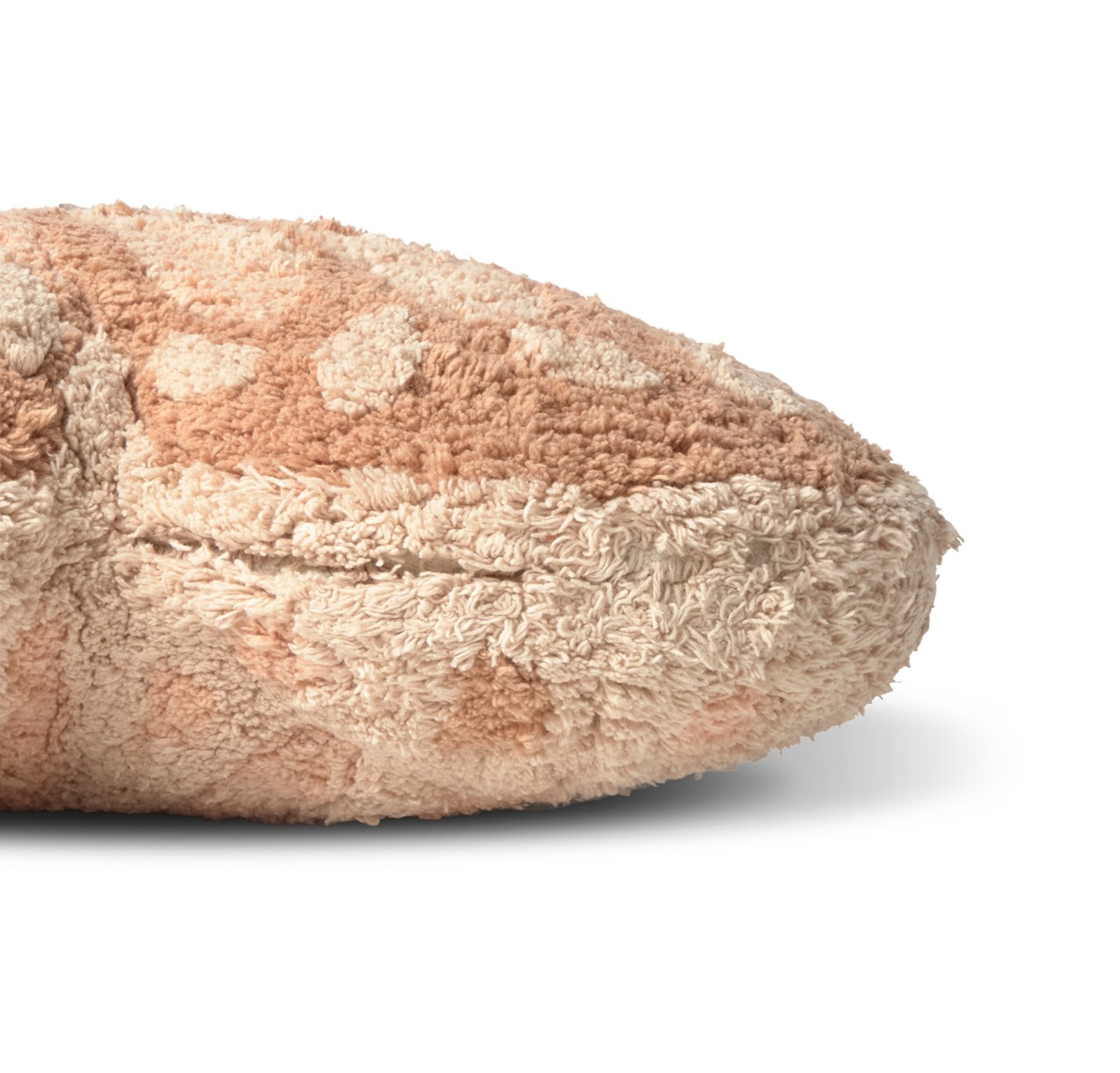 Nahaufnahme eines beige und hellbraun gemusterten Plüschkissens mit sichtbarer Steppnaht auf weißem Hintergrund.
